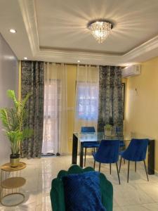 a dining room with a blue table and chairs at At Home Lisda in Yaoundé