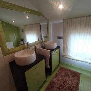a bathroom with two sinks and a large mirror at A de Bego in Mougás