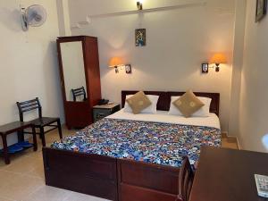 1 dormitorio con cama, mesa y espejo en Kim Hotel, en Ho Chi Minh