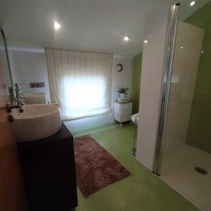ein Bad mit einem Waschbecken und einer Dusche in der Unterkunft A de Bego in Mougás