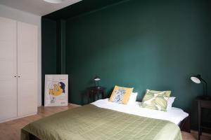 グダニスクにあるApartament blisko Starego Miastaの緑の壁のベッドルーム1室、ベッド1台が備わります。