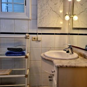 bagno con lavandino, specchio e asciugamani di Abades El Viejo Barco ad Abades