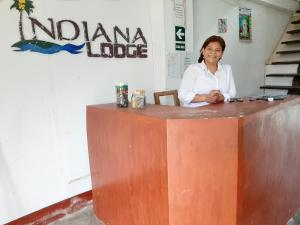 una mujer está sentada en un mostrador de madera en Indiana Lodge, en Mazán