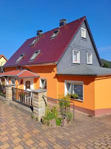 ein großes orangefarbenes Haus mit rotem Dach in der Unterkunft Feriendomizil Elbsandsteingebirge in Königstein an der Elbe