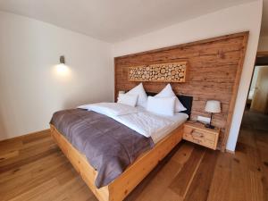フルプメスにあるFerienlandhaus Höferの大きなベッドと木製の壁が備わるベッドルーム1室が備わります。