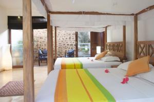 2 camas en una habitación de hotel con 2 camas en Ratnakara, en Dondra East
