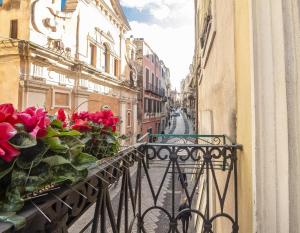 a balcony with red roses on a city street at Hotel Vittorio Emanuele in Sassari