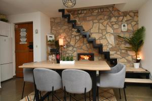 a dining room with a table and a fireplace at Robinson crusoe style house "MASLINA'' in Škrip