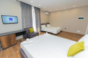 a hotel room with two beds and a couch at Hotel Viroi in Vlorë