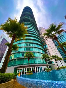 een hoog gebouw met palmbomen ervoor bij Vortex suites near by KLCC in Kuala Lumpur