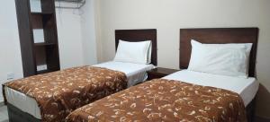2 camas en una habitación de hotel en Baraka Al Aqaba Hotel Suites, en Áqaba