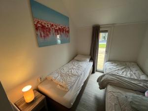 2 camas individuales en una habitación con ventana en Ferienhaus tinydroom im Europarcs Bad Hoophuizen am Veluwemeer en Hulshorst