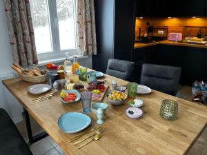 a wooden table with plates and bowls of food on it at Ferienhaus Thonjoergl in Gnas