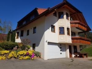 a large white house with a large garage at Ferienwohnung Sprauer in Baiersbronn
