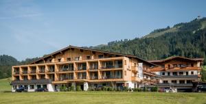 a large building with a mountain in the background at Hotel Kitzspitz in Sankt Jakob in Haus