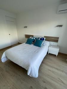 a large white bed with blue pillows in a room at Beta's Beach in Blanes