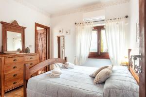 a bedroom with a bed and a dresser and a window at Villa Regina Margherita in Olbia