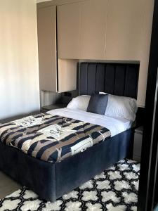 a bed with a black headboard in a bedroom at PARANAIS APARTMENT 2 in Nairobi
