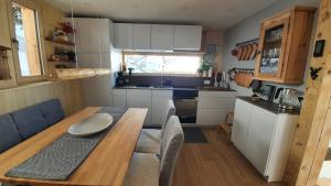 a small kitchen with a wooden table in a tiny house at Chalet Baumfuchs direkt an der Talabfahrt Belalp in Blatten bei Naters