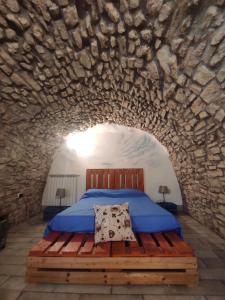 a bedroom with a bed in a stone wall at Casa Vacanze Faeto in Faeto