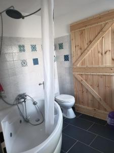 a bathroom with a white tub and a toilet at Hochgratstrasse in Oberreute