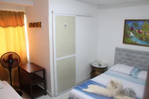 a bedroom with a bed and a glass door at Hostal Alto de la Montaña in Minca