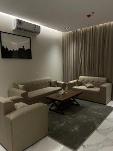 a living room with couches and a table at سيفن سون للأجنحة الفندقية in Abha