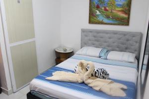 a bed with a stuffed animal laying on it at Hostal Alto de la Montaña in Minca