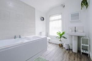 a white bathroom with a sink and a toilet at Hope House Chester Sleeps 6 by Heritage Stays in Hough Green