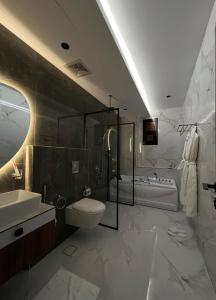 سيفن سون للأجنحة الفندقية في أبها: حمام مع مرحاض ومغسلة وحوض استحمام