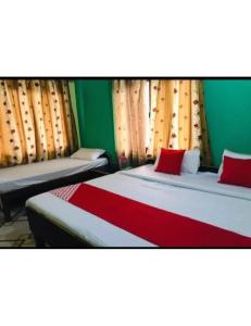 Uttarkāshi的住宿－Raj Palace, Uttarkashi，一间卧室设有两张带红色和绿色墙壁的床。