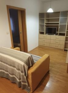 a room with a bed and a couch and a television at Odmor u Zagrebu in Zagreb