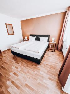 1 dormitorio con 1 cama grande y suelo de madera en Zentral Hotel en Bad Füssing