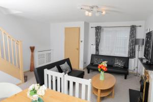 a living room with a couch and a table at Entire 3 bedroom house, 3 toilets, 2 baths, sleep 9 with free parking in Thamesmead
