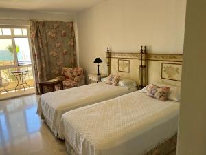 2 łóżka w pokoju hotelowym z balkonem w obiekcie Apartamento Puerto Sotogrande Marina w mieście Sotogrande
