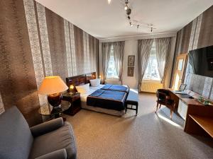 1 dormitorio con 1 cama y 1 sofá en una habitación en ZU DEN LINDEN - RADEBEUL Pension mit Restaurant, en Radebeul