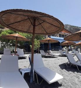 a group of chairs and umbrellas on a beach at Agia Roumeli APARTMENT in Agia Roumeli +6 photos