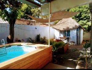 瓦加杜古的住宿－Le BASTA，一个带遮阳伞的庭院内的游泳池