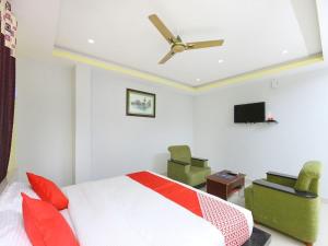 Sai Golden Rooms في تيروباتي: غرفة نوم بسرير ومروحة سقف