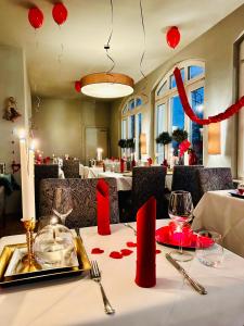 una mesa en un restaurante con adornos rojos. en ZU DEN LINDEN - RADEBEUL Pension mit Restaurant, en Radebeul