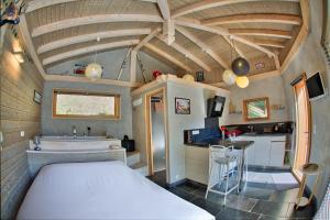 Cette chambre comprend un lit, un évier et une cuisine. dans l'établissement Chalet dans les Arbres, à Saint-Jean-dʼAulps
