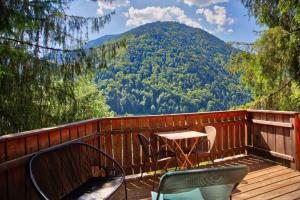 una mesa y sillas en una terraza con vistas a la montaña en Chalet dans les Arbres, en Saint-Jean-dʼAulps