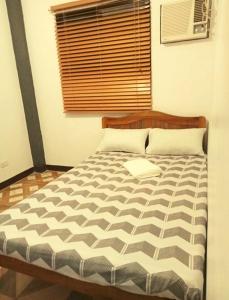 a bedroom with a bed with a wooden head board at Dos Casa Guest House in Puerto Princesa City