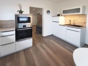 a kitchen with white cabinets and a sink at Rhön - Nestchen in Unteralba