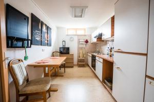 a small kitchen with a table and a refrigerator at Ländliche 2-Zimmer Wohnung in Bad Ditzenbach