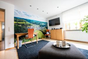 a living room with a large painting on the wall at Ländliche 2-Zimmer Wohnung in Bad Ditzenbach