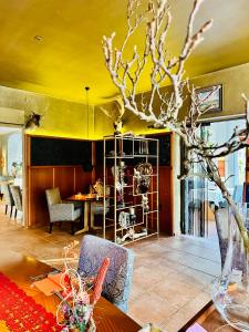 a dining room with a table and a yellow ceiling at ZU DEN LINDEN - RADEBEUL Pension mit Restaurant in Radebeul