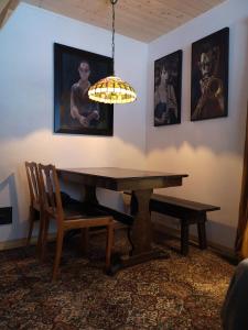 een eetkamer met een houten tafel en een kroonluchter bij Metsaräägu Wellness 