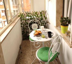 a table with a plate of croissants on a balcony at Fracco's House S. Marinella fronte mare 36' di treno da Roma in Santa Marinella