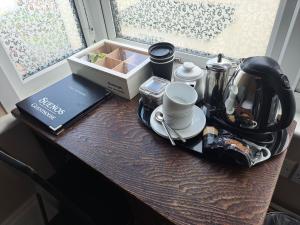 un tavolo con set per la preparazione del tè e una finestra di Suenos Guesthouse a Southend-on-Sea